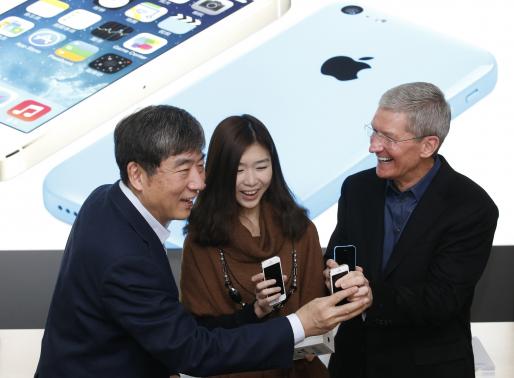 Apple Inc. CEO Tim Cook and China Mobile's Chairman Xi Guohua pose with a customer at an event celebrating the launch of Apple's iPhone on China Mobile's network in Beijing