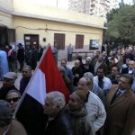 People queue outside a polling centre to vote in a referendum on Egypt's new constitution in Cairo
