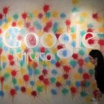 A woman walks past the Google Chicago headquarters logo in Chicago