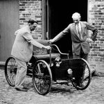 Henry Ford, right, stands with his first car built in 1892