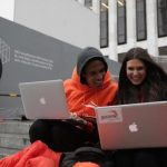 Keenen Thompson and Jessica Mellow surf the web while waiting in line to buy an iPhone 4S at the Apple Store on 5th Avenue in New York