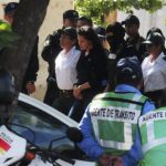 Mexican citizen Raquel Alatorre Correa is escorted by police officers at the airport in Managua