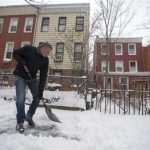 New York City Mayor Bill de Blasio clears the sidewalk of snow in front of his Brooklyn home in New York