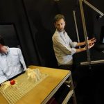 Sean Follmer looks towards his image on a computer screen