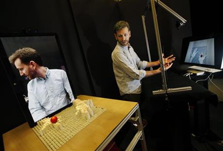 Sean Follmer looks towards his image on a computer screen