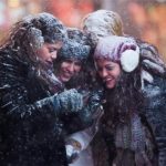 Tourists look at a camera in snowstorm in Times Square, Midtown, New York
