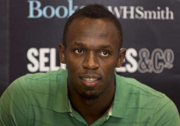 Jamaican athlete Usain Bolt poses for photographers as he signs copies of his autobiography, "Faster than Lightning," at Selfridges in central London