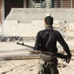 A Free Syrian Army fighter carries his weapon on one of the battlefronts in Jobar, a suburb of Damascus