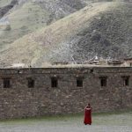 A Tibetan monk uses a mobile phone near the Dzamthang Jonang monastery in Barma township