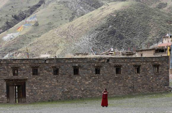 A Tibetan monk uses a mobile phone near the Dzamthang Jonang monastery in Barma township