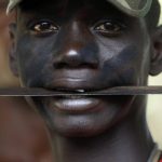 A fighter from the Christian "anti-balaka" militia holds a machete in his mouth at the headquarters in the northern Bangui suburb of Boeing