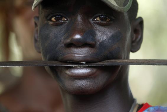 A fighter from the Christian "anti-balaka" militia holds a machete in his mouth at the headquarters in the northern Bangui suburb of Boeing