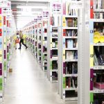 Worker collects items to pack into boxes at Amazon's logistics centre in Graben