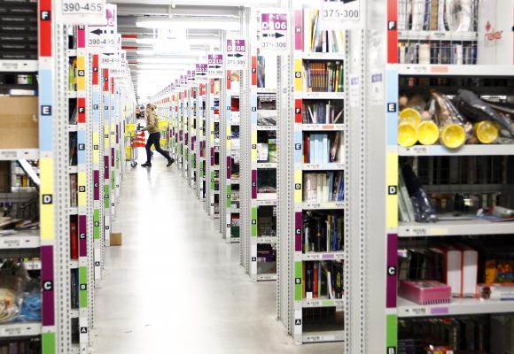 Worker collects items to pack into boxes at Amazon's logistics centre in Graben