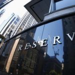 A construction crane is reflected on the Reserve Bank of Australia building in central Sydney
