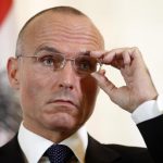Defence Minister Klug adjusts his glasses during a news conference in Vienna