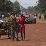 A French peacekeeping soldier searches a man for weapons in the district of Miskine of the capital Bangui