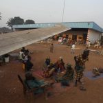 A family displaced by inter-communal violence in the country sit near a plane in a camp for displaced persons at Bangui M'Poko International Airport