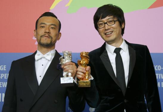 Actor Liao Fan and director Diao Yinan pose with Silver Bear for Best Actor and Golden Bear for Best film after awards ceremony of 64th Berlinale International Film Festival in Berlin