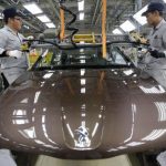 Employees work at a production line of a Dongfeng Peugeot Citroen Automobile factory in Wuhan