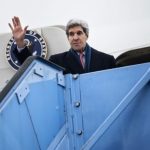 U.S. Secretary of State Kerry waves while boarding his plane at Franz-Josef-Strauss Airport in Munich