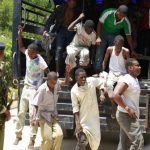 Muslim youths, who were detained by police from Sunday's raid at the Masjid Musa mosque, disembark from a vehicle as they arrive at a court in Shanzu