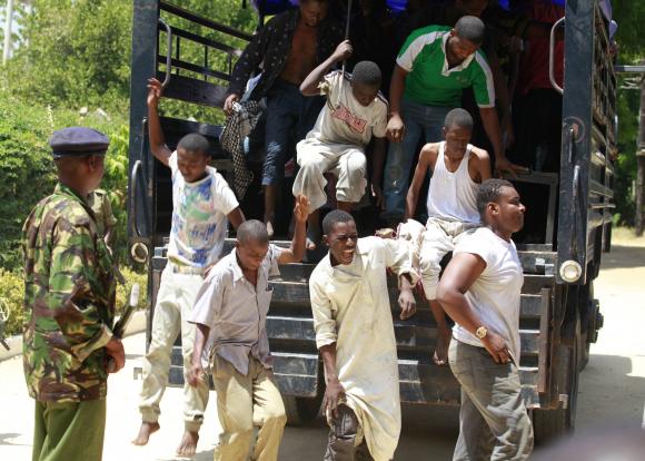 Muslim youths, who were detained by police from Sunday's raid at the Masjid Musa mosque, disembark from a vehicle as they arrive at a court in Shanzu