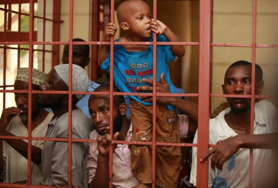 A boy, who was with fellow Muslims detained by police from Sunday's raid at the Masjid Mussa mosque, climb in a cell as the men wait to be arraigned at a court in Shanzu