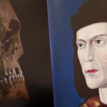 A television image of King Richard III's skull is seen next to a portrait of him during a news conference in Leicester