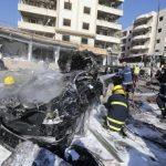 Civil defence members put out a fire at the site of an explosion in the southern suburbs of Beirut