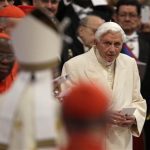 Pope Emeritus Benedict XVI looks at Pope Francis, left with back to camera