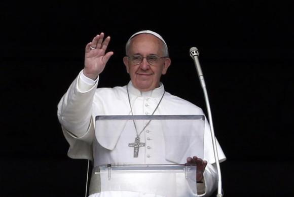Pope Francis waves to the faithful as he appears at the window of his future private apartment in St. Peter's Square, during the Angelus prayer at the Vatican