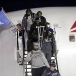 Seahawks' Sherman carries his crutches as he exits the team's chartered flight home after winning NFL Super Bowl XLVIII in Seattle