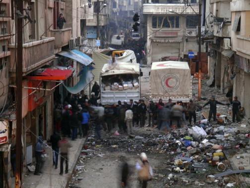 Syrian Arab Red Crescent trucks stand in the besieged neighbourhoods of Homs to supply humanitarian aid