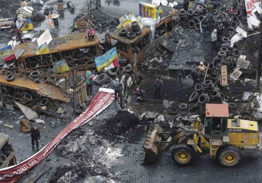 A bulldozer removes barricades at the site of recent clashes with riot police in Kiev