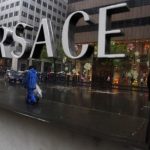 A sign is seen for a high-end retail store along 5th Avenue in New York