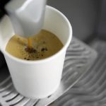 A coffee machine pours coffee into a paper cup in Kiev