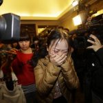 A relative of a passenger of Malaysia Airlines flight MH370 cries as she walks past journalists in Beijing