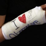 Cathey Park shows her cast signed by U.S. President Obama after he spoke about health insurance at Faneuil Hall in Boston