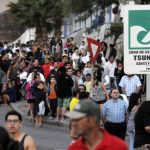 People stay on higher grounds in a tsunami safety zone after a magnitude 6.7 earthquake shook the region, in Iquique city, north of Santiago