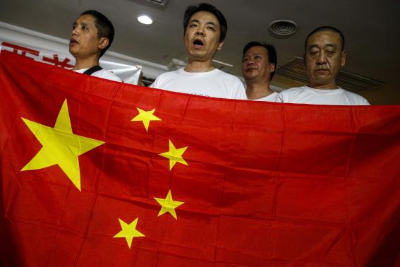 Chinese relatives of passengers onboard the missing flight MH370 hold China's national flag during a news conference in Subang Jaya