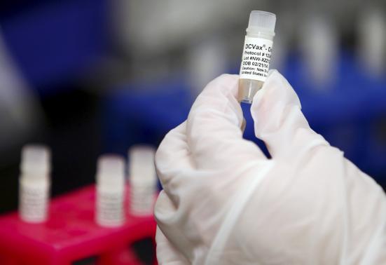 A manufacturing associate holds a vial with a DCVax-L label in a Northwest Biotherapeutics laboratory in Memphis