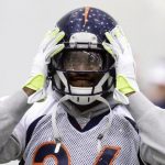 Denver Broncos cornerback Bailey adjusts his helmet during their practice session for the Super Bowl in Florham Park