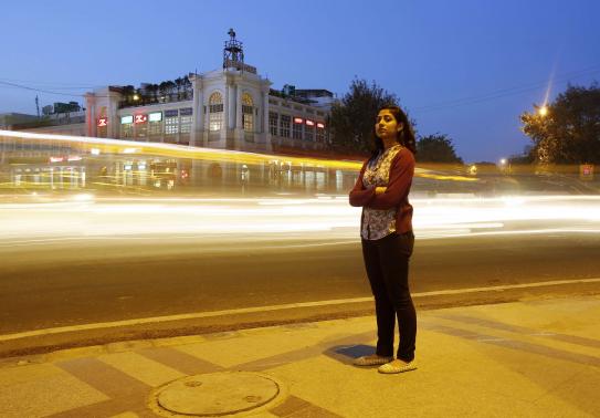 Inayat Naomi Ramdas, 21, poses for a photograph at a busy traffic intersection in New Delhi