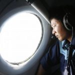 Military officer Nguyen Tran looks out from a Vietnam Air Force AN-26 aircraft during a mission to find the missing Malaysia Airlines flight MH370, off Con Dao island