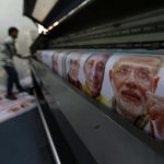 A worker operates a machine to print banners of Hindu nationalist Modi, prime ministerial candidate for India's main opposition BJP ahead of the general elections in Ghaziabad