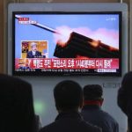 Passengers watch a television program showing reports on North Korea's plan to conduct live-fire drills, at a railway station in Seoul