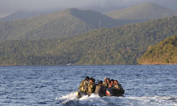Members of Philippine marines are transported on rubber boat from patrol ship after conducting mission on disputed Second Thomas Shoal as they make way to naval forces camp in Palawan