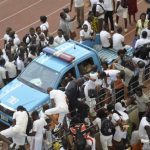 Applicants scale a fence during a recruitment drive for the Nigeria Immigration Service in Abuja