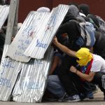 Anti-government protesters use makeshift shields as protection during clashes with the National Guard at a rally against Venezuela's President Nicolas Maduro government in Caracas